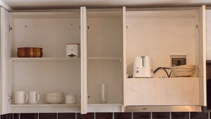 A kitchen with open cabinets, a toaster, and a coffee maker. - Escapada en Valparaíso (Valparaíso)