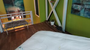 A room with a bed, a bench, a cactus, and a painting on the wall. - Apart hotel JaguiHaus (Valparaíso)