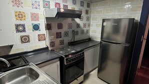 Een keuken met een fornuis, oven en koelkast.