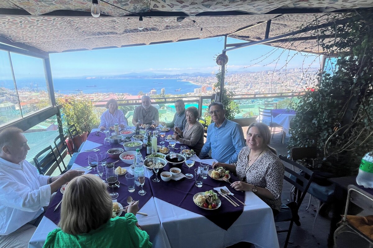 A group of people dining at a table with a city view.