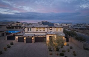 Ein zweistöckiges Haus mit Garage, Solaranlage und Schwimmbecken im Hintergrund.