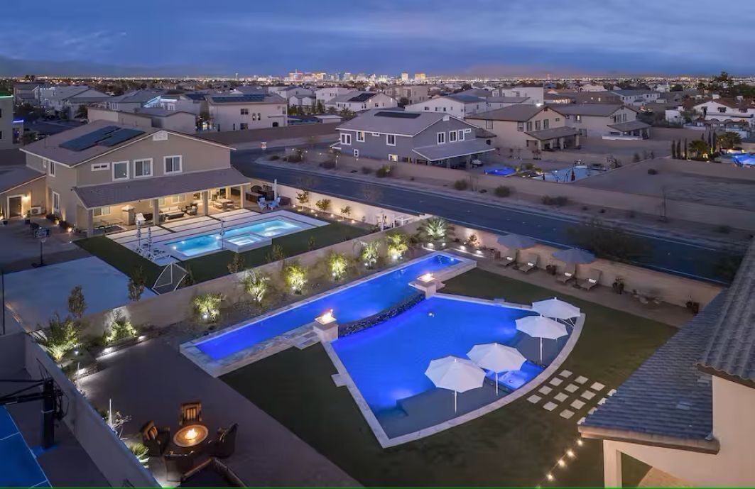 Zona residencial con piscina, mobiliario exterior y vistas a la ciudad.