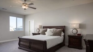 Una camera da letto con un letto grande, due comodini, una ventola a soffitto e una finestra.