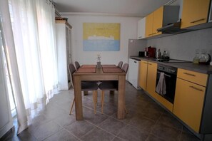 Une cuisine compacte comprenant une table à manger, des chaises et une machine à café.