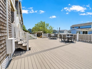 A wooden deck with outdoor seating and a white fence.