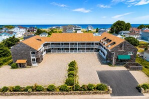 A large building with a central courtyard, surrounded by residential houses, and a view of the sea. - Ocean Club at Atlantic Beach  (Westerly)