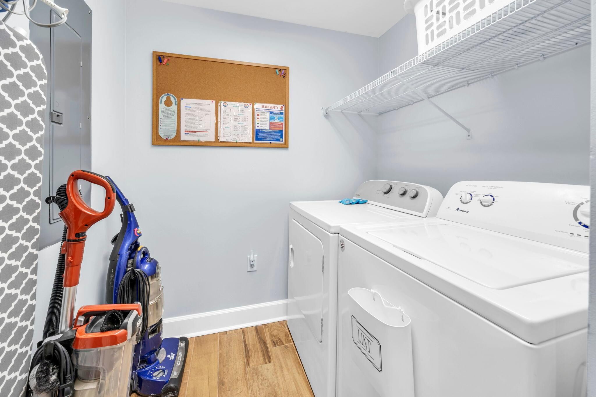 Une buanderie équipée d’un lave-linge, de deux sèche-linge et d’un aspirateur.