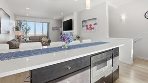 A modern kitchen with a central island, built-in oven, and microwave. - Modern Hideaway with Private Terrace in Downtown (Anchorage)
