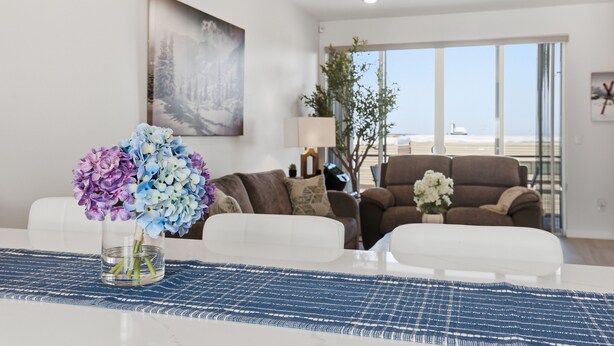 A modern living room with a white sofa set, a glass coffee table, and a painting on the wall. - Modern Hideaway with Private Terrace in Downtown (Anchorage)