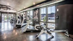 Une salle de sport équipée de tapis de course, de vélos d’appartement et d’appareils de musculation.