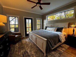 Ein Schlafzimmer mit Bett, Schminktisch, Nachttisch, Lampe und Deckenventilator.