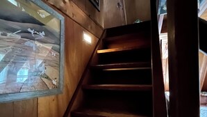 Una escalera de madera con vista al interior a través de un ventanal.