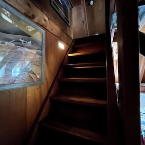 A wooden staircase with a view of the interior through a window.