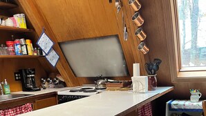 Una cocina con una isla de madera, taburetes de bar y varios electrodomésticos.