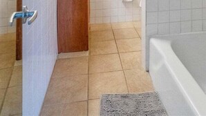 Un baño con dos lavamanos, ducha y perchero para toallas.
