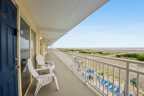 A balcony with white chairs and a view of the beach. - 1 Bedroom Beach Condo with a Pool & Balcony (Wildwood Crest)