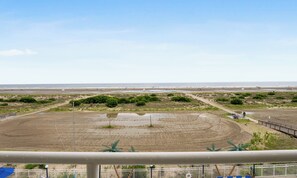 A coastal landscape with a sandy beach, a water body, and a wooden walkway. - 1 Bedroom Beach Condo with a Pool & Balcony (Wildwood Crest)