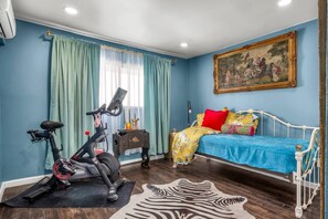 Ein Schlafzimmer mit einem Bett, einem Heimtrainer und einem Zebra-Teppich.