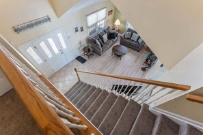 A staircase leading to a living room with a sofa, coffee table, and a lamp. - Gorgeous 4 Bedroom Townhome in Diamond Beach (Wildwood Crest)
