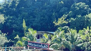 Un barco amarrado con un cartel que dice 'HOLD IN THE WAY' y un restaurante con terraza.
