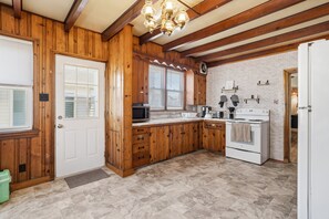 A kitchen with wooden cabinets, a stove, and a microwave. - North Wildwood 4 Bedroom with Excellent Sleeping Arrangements (North Wildwood)