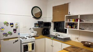 A kitchen with a refrigerator, stove, microwave, and various kitchen appliances.