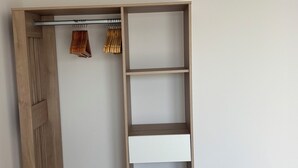 Habitación con armario empotrado que incluye estantes y espacio para colgar ropa.