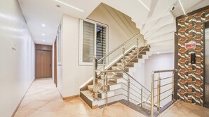 Ein modernes Interieur mit Treppe, Brandschutztürschild und Wand mit Muster.
