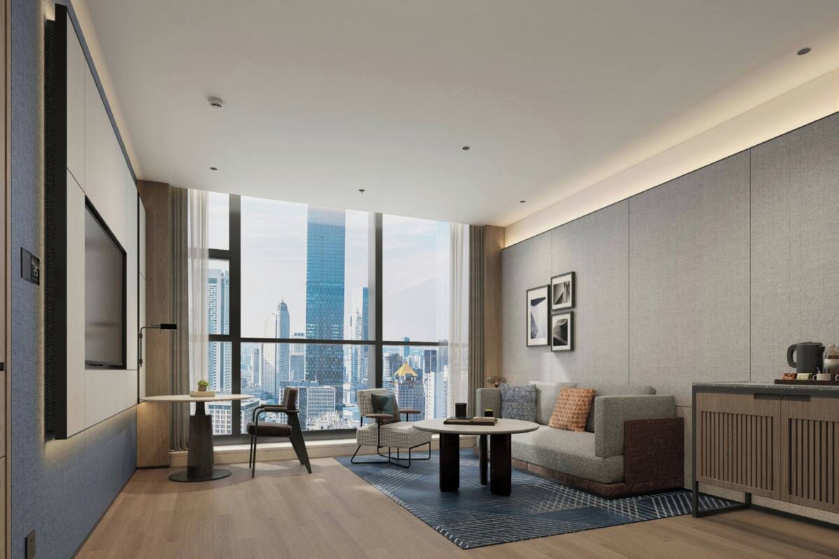 Una sala moderna con vistas a la ciudad, un sofá, una mesa de centro y un comedor.