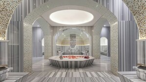 A luxurious bathroom with a freestanding bathtub, marble flooring, and striped walls.