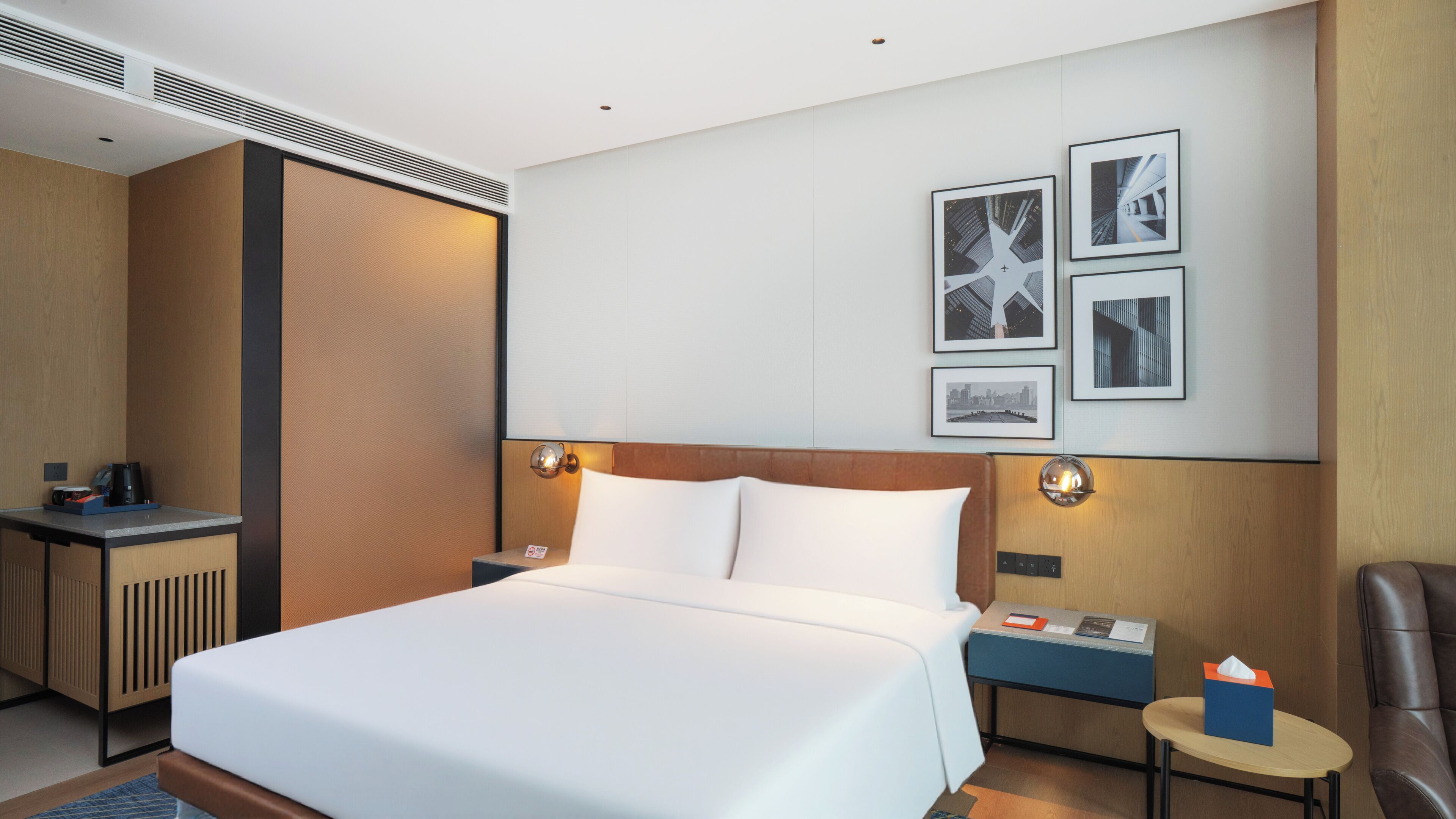 Una habitación de hotel con una cama grande, mesitas de noche, un escritorio y una silla.
