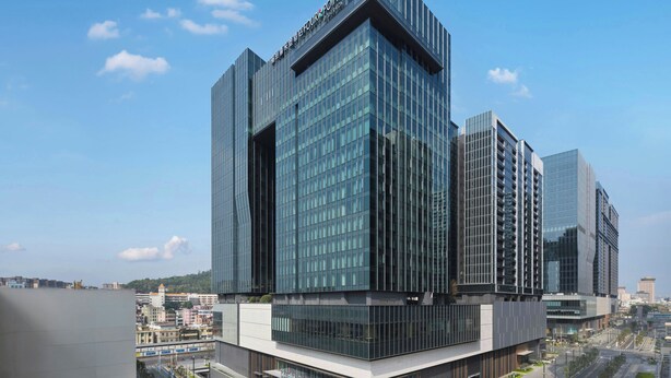 A modern high-rise building with a glass facade, multiple floors, and a prominent entrance. - Four Points By Sheraton Shenzhen Airport (Shenzhen)