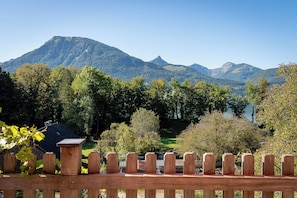 A wooden fence with a view of a mountain range and a lake. - Apartment Amethyst in Haus Alpenblick (Sankt Wolfgang)