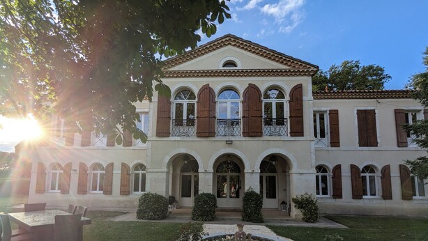 A two-story building with a symmetrical facade, arched windows, and a central entrance. - Charming estate with swimming pool - Group gîte for 15 people. (Castéra-Verduzan)