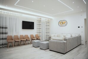 A modern living room with a sofa, chairs, a flat-screen TV, and a world map artwork. - LUXURY SEA EZLIN HOUSE (Savona)