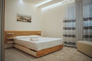 A bedroom with a wooden bed, a nightstand, a wall-mounted picture, and a window with curtains. - LUXURY SEA EZLIN HOUSE (Savona)