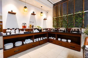 A buffet setup with various dishes and utensils, wooden shelves, and hanging lights. - Zip by Spree Hotels Silvassa Indore (Indore)