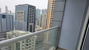 A high-rise building with a glass balcony overlooking a cityscape.