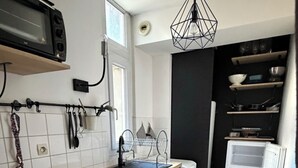 A compact kitchen with a microwave, sink, and dishwasher. - Cozy 1-bedroom studio in nice Angers with AC (Angers)