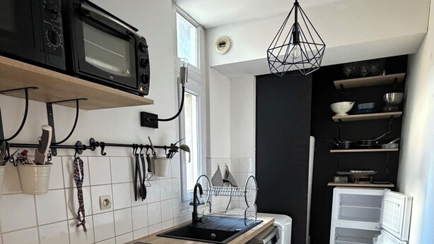 A compact kitchen with a microwave, sink, and a small refrigerator. - Cozy 1-bedroom studio in nice Angers with AC (Angers)