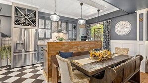 Una cocina moderna con una isla integrada, electrodomésticos de acero inoxidable e iluminación colgante.