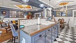 Una cocina moderna con una isla central, iluminación colgante y suelo a cuadros.