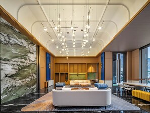 A modern hotel lobby with a marble wall, a white sofa, and a ceiling with hanging lights. - Holiday Inn Express Luding by IHG (Garze)