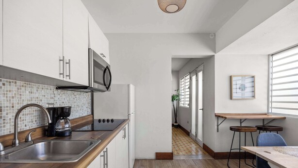 A modern kitchen with a stainless steel sink, a microwave, and a coffee maker. - 2-Bedroom | Near T-Mobile District & Calle Cerra (San Juan)