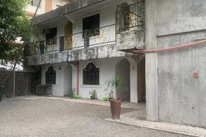 A two-story building with balconies, a courtyard, and a potted plant.