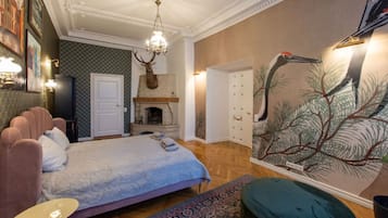 Un dormitorio con cama, chimenea, candelabro y un mural en la pared.