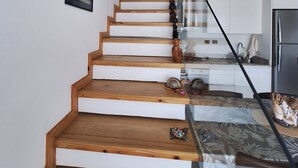 A staircase with wooden steps leading to a kitchen area with a refrigerator. - Exclusive penthouse in Dominicus with 5 pools in a tropical setting (Dominicus)