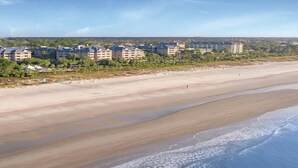 Een kusthotel met meerdere gebouwen, een zandstrand en uitzicht op de oceaan.