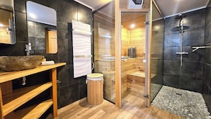 A modern bathroom with a wooden vanity, a large mirror, a sauna, and a shower area. - 2P gîte with sauna on the Route des Vins near Colmar (Bergheim)