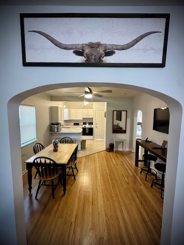 A dining area with a wooden table and chairs, a kitchen in the background, and a ceiling fan. - Cozy & Convenient Casper Stay (Casper)
